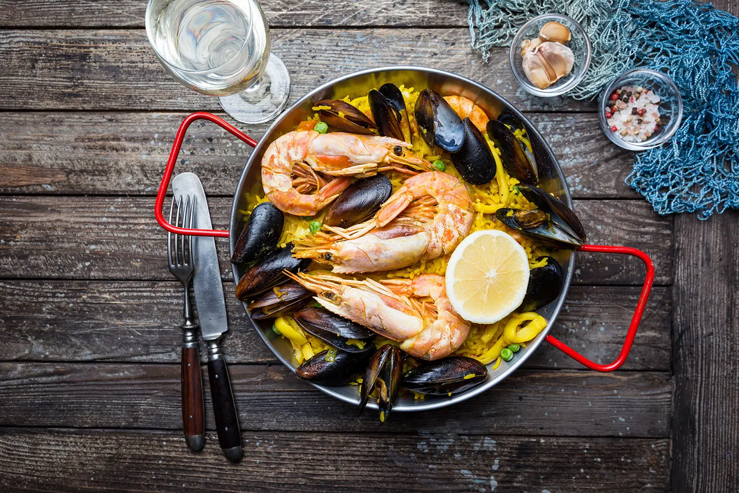Paëlla aux crevettes et aux moules dans sa poêle, citron et vin blanc